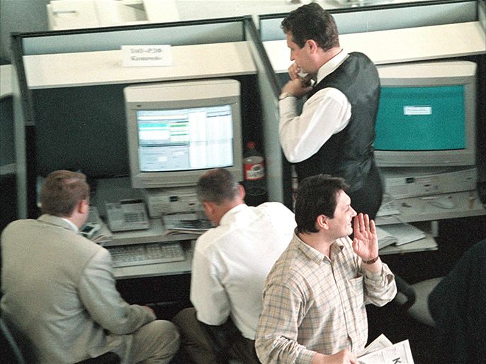 MOS04-19980814-MOSCOW, RUSSIAN FEDERATION: A trader whispers information, while holding "Kommersant" paper in his hand, as his collegues study the information on the monitor in the working hall of Moscow stock exchange, Friday 14 August 1998 . Stocks have lost almost 50 percent since July 20 and almost half of those losses have been registered since Monday in a black week for Russia's financial system. EPA PHOTO/SERGEY CHIRIKOV