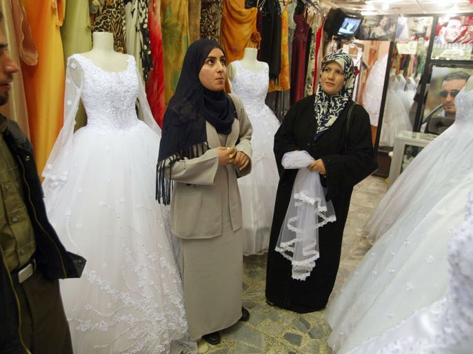 BAGHDAD, IRAQ- NOVEMBER 26: A couple searches for a wedding dress November 26, 2003 in the Mansour shopping district of Baghdad, Iraq. Coalition officials are hopeful that Iraqi's will continue to get back on their feet after the American led invasion to topple Saddam Hussein. (Photo by Joe Raedle/Getty Images)