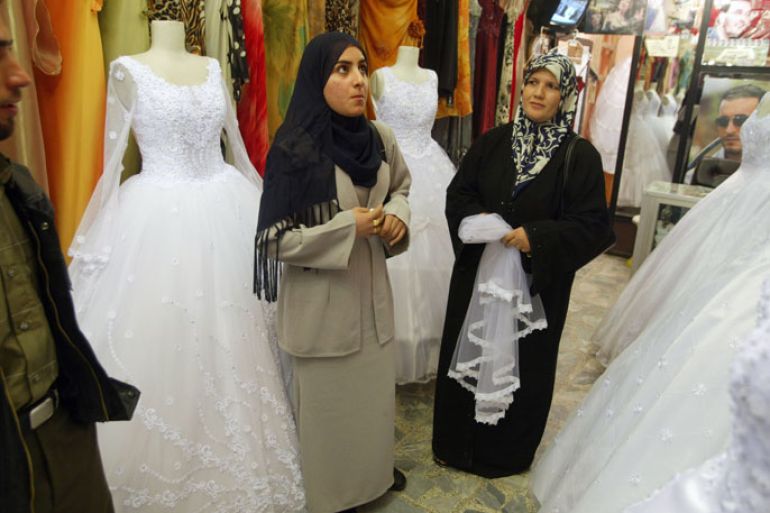 BAGHDAD, IRAQ- NOVEMBER 26: A couple searches for a wedding dress November 26, 2003 in the Mansour shopping district of Baghdad, Iraq. Coalition officials are hopeful that Iraqi's will continue to get back on their feet after the American led invasion to topple Saddam Hussein. (Photo by Joe Raedle/Getty Images)