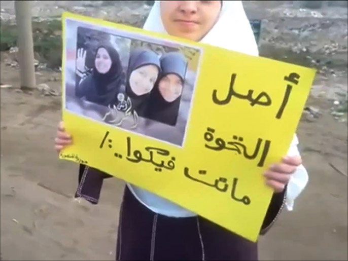 ‪فتاة تحمل لافتة تأييد لفتيات‬ (الجزيرة-أرشيف)