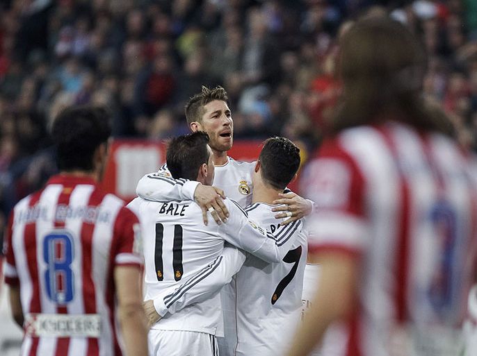 epa04106510 Real Madrid's Portuguese striker Cristiano Ronaldo (R) jubilates with his team mates Welsh midfielder Gareth Bale (L) and defender Sergio Ramos (C) his goal against Atletico Madrid during their Primera Division soccer match played at Vicente Calderon stadium in Madrid, Spain on 02 March 2014. EPA
