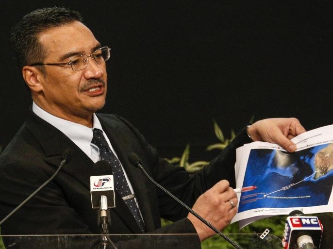 Malaysia's acting Transport Minister Hishammuddin Hussein holds satellite images as he speaks about the search for the missing Malaysia Airlines Flight MH370, during a news conference at Putra World Trade Center in Kuala Lumpur March 26, 2014. New satellite images have revealed more than 100 objects in the southern Indian Ocean that could be debris from the Malaysian jetliner missing for 18 days with 239 people on board, Hishammuddin said on Wednesday. REUTERS/Athit Perawongmetha (MALAYSIA - Tags: DISASTER TRANSPORT POLITICS TPX IMAGES OF THE DAY)