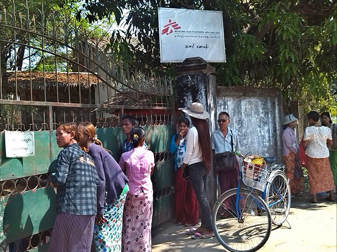 epa04104626 A photo made available in 01 March 2014 shows people wait outside the closed door of Medecins Sans Frontieres (MSF) or Doctors Without Borders's group office at a township in Yangon, Myanmar, 28 February 2014. The international aid group Doctors Without Borders has been ordered to stop its clinics and end all operations in the country by Myanmar government. EPA/YE NAUNG/ 7 DAYS NEWS