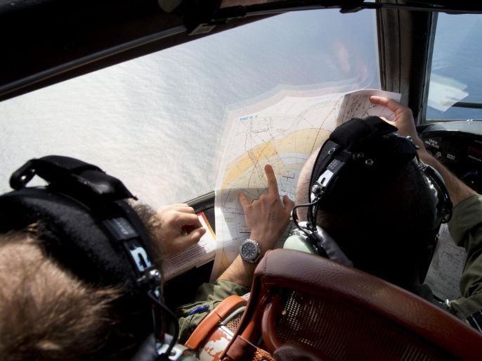 Flight Lt. Jayson Nichols looks at a map as he flies aboard a Royal Australian Air Force AP-3C Orion aircraft during a search operation of the missing Malaysian Airlines flight MH370 over the southern Indian Ocean, Thursday, March 27, 2014. Planes and ships searching for debris suspected of being from the downed Malaysia Airlines jetliner failed to find any Thursday before bad weather cut their hunt short in a setback that came as Thailand said its satellite had spotted even more suspect objects. (AP Photo/Michael Martina, Pool)