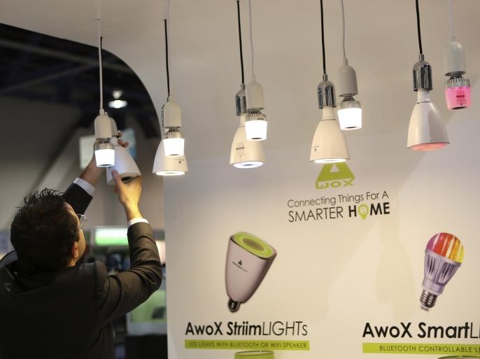 A man changes a bulb in Awox Smart Lights, which features a Bluetooth controllable LED light, at the annual Consumer Electronics Show (CES) in Las Vegas, Nevada January 8, 2014. REUTERS/Robert Galbraith (UNITED STATES - Tags: SCIENCE TECHNOLOGY BUSINESS)