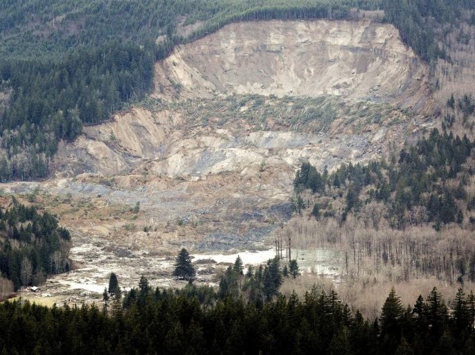 In this aerial photo taken Saturday, March 23, 2014, a massive mudslide is shown in between the towns of Darrington, Wash., and Arlington, Wash. The slide killed at least three people and many people are still unaccounted for, and authorities said Sunday that searchers were flying over the one-square-mile mudslide in helicopters. (The Seattle Times, Marcus Yam) MANDATORY CREDIT TO: MARCUS YAM/THE SEATTLE TIMES