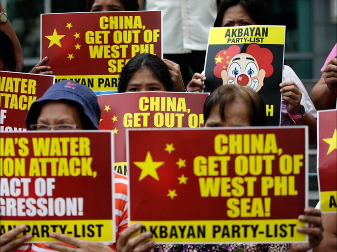 epa04107282 Protesters rally outside the Chinese Consular Office in the Makati financial district, Manila, Philippines, 03 March 2014, to protest against the firing of water cannon on Filipino fishermen by Chinese maritime vessels in the West Philippine Sea. EPA/DENNIS M. SABANGAN