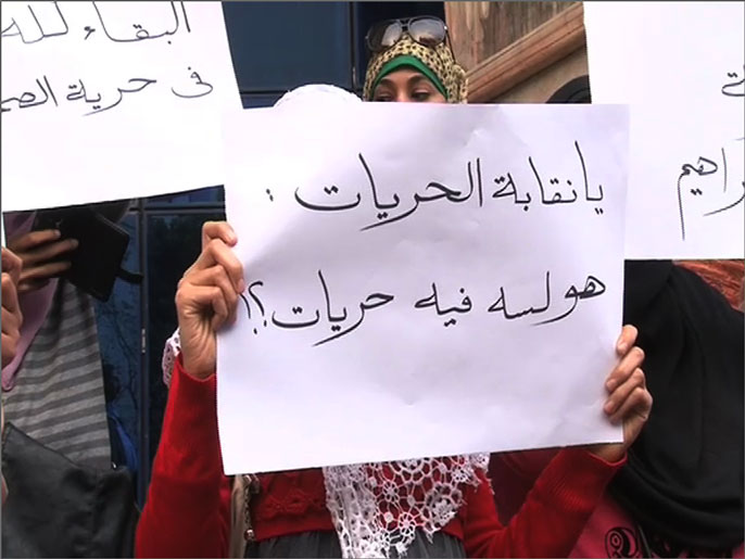 ‪إحدى صحفيات الحرية والعدالة تحمل لافتة منددة بحبس سماح إبراهيم‬ (الجزيرة نت)