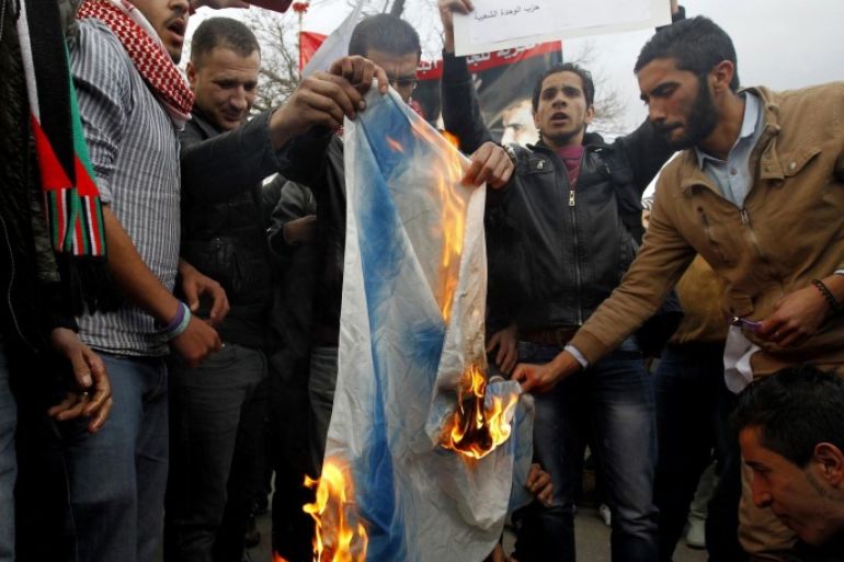 Jordanian demonstrators burn an Israeli flag during a protest in front of the parliament in Amman March 11, 2014. The protesters were demonstrating against the shooting of a Palestinian judge from Jordan by Israeli soldiers on Monday, local media reported. Israeli soldiers shot and killed the judge in an altercation at a crossing point between Jordan and the Israeli-occupied West Bank, Palestinian officials said. The Israeli military said the man had tried to seize a soldier's gun at the Allenby bridge, which spans the Jordan River, and that troops had then shot him. REUTERS/Muhammad Hamed (JORDAN - Tags: POLITICS CIVIL UNREST)