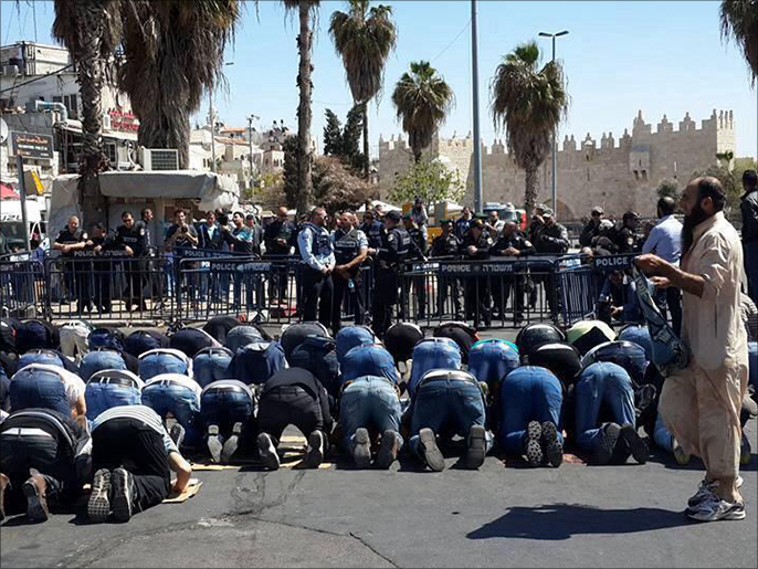 فلسطينيون دون خمسين عاما منعهم الاحتلال من دخول الأقصى يؤدون صلاة الجمعة في شوارع القدس المحتلة (الجزيرة-أرشيف)