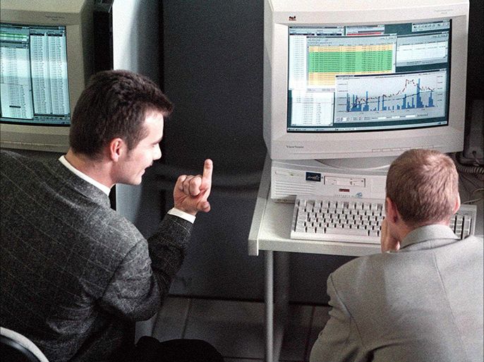 Traders argue about the future of the Russian currency while studying graphics on the monitors in the working hall of the Moscow stock exchange, Tuesday18 Aug. 1998