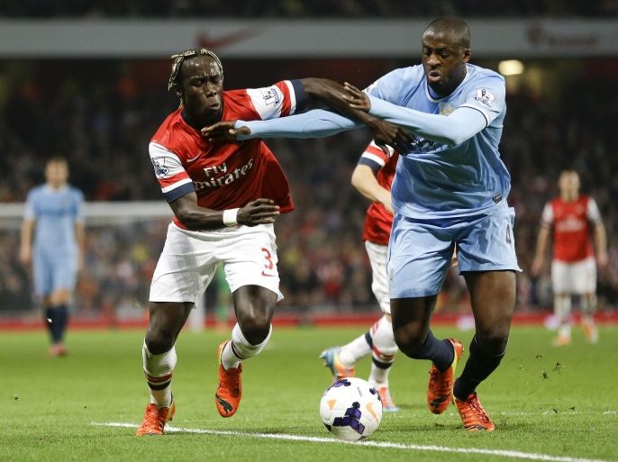 Arsenal's Bacary Sagna, left, vies for the ball with Manchester City's Yaya Toure during the English Premier League soccer match between Arsenal and Manchester City at the Emirates stadium in London, Saturday, March 29, 2014. (AP Photo/Kirsty Wigglesworth)