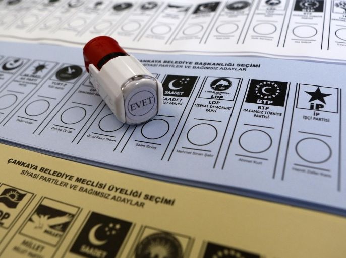 Ballots are seen under a stamp seen at a polling station in Ankara March 30, 2014. Turkey's Prime Minister Tayyip Erdogan looks set to win Sunday's municipal elections that have become a crisis referendum on his 10-year rule as he tries to ward off graft allegations and stem a stream of damaging security leaks. Erdogan and his Islamist-rooted AK Party blame the leaks on "traitors" embedded in the Turkish state and he has been criss-crossing the nation of 77 million during weeks of hectic campaigning to rally his conservative core voters. The word in Turkish "evet" on the stamp means "yes" in English. REUTERS/Umit Bektas (TURKEY - Tags: POLITICS ELECTIONS)