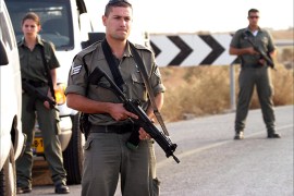 Armed Israeli police stand beside to vans carrying five Jordanians being releaseuesday, 25 November 2003 at the checkpoint leading to the Allenby Bridge outside of Jericho on the West Bank.Israel is due to release ten Jordanians held in its prisons as a goodwill gesture for the Eid al-Fitr Moslem holiday. One of the prisoners is a woman. A female Israeli office stands with an automatic rifle between the two vans as they group before crossing the border out of sight of journalists. EPA/JIM HOLLANDER