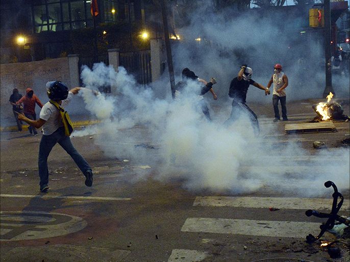 Demonstrators clash with riot police during an anti-government protest in east Caracas, on March 12, 2014. A young man was shot dead early today, in a confused event during protests in the city of Valencia, in northern Venezuela.