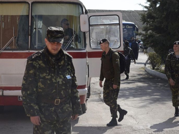 Ukrainian marines prepare to leave their base in Feodosia, Crimea, Tuesday, March 25, 2014. In Crimea, Ukrainian soldiers piled onto buses and began their journey to Ukrainian territory on Tuesday, as former comrades saluted them from outside a base overrun by Russian forces. (AP Photo/Valeriy Kulyk)