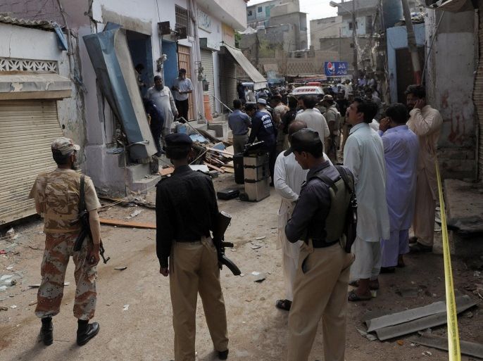 Pakistani security officials inspect the site of a bomb attack in Karachi on April 24, 2014. A bomb targeting a local police official killed at least four people and wounded 15 others in Pakistan's port city of Karachi, police said. AFP PHOTO/Rizwan TABASSUM
