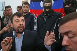 Denis Pushilin, foreground center, spokesman of the self-appointed Donetsk People’s Republic, speaks to reporters inside the regional administration building seized earlier in Donetsk, Ukraine, Friday, April 18, 2014. Pushilin told reporters that the insurgents do not recognize the Ukrainian government as legitimate. Pro-Russian insurgents in Ukraine’s east who have been occupying government buildings in more than 10 cities said Friday they will only leave them if the interim government in Kiev resigns.(AP Photo/Sergei Grits)