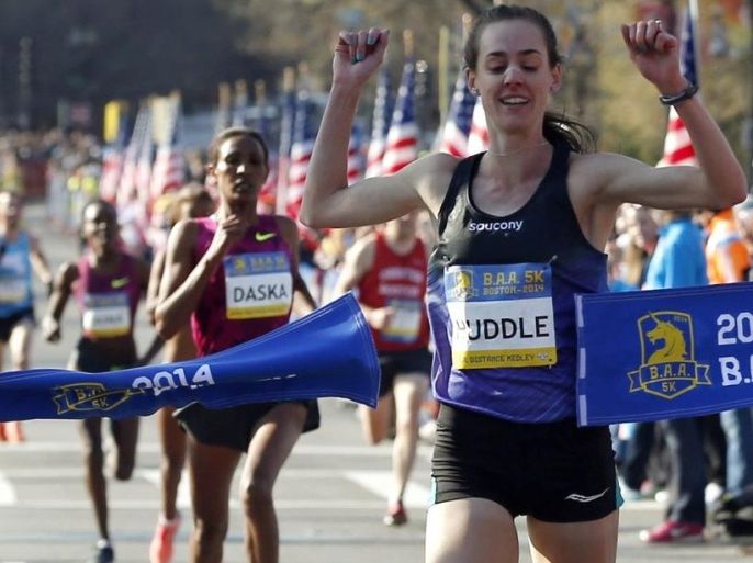 Molly Huddle, of Providence, R.I., breaks the tape to win the women's division in the 5-kilometer run Saturday, April 19, 2014, in Boston in advance of Monday's 118th Boston Marathon. (AP Photo/Elise Amendola)