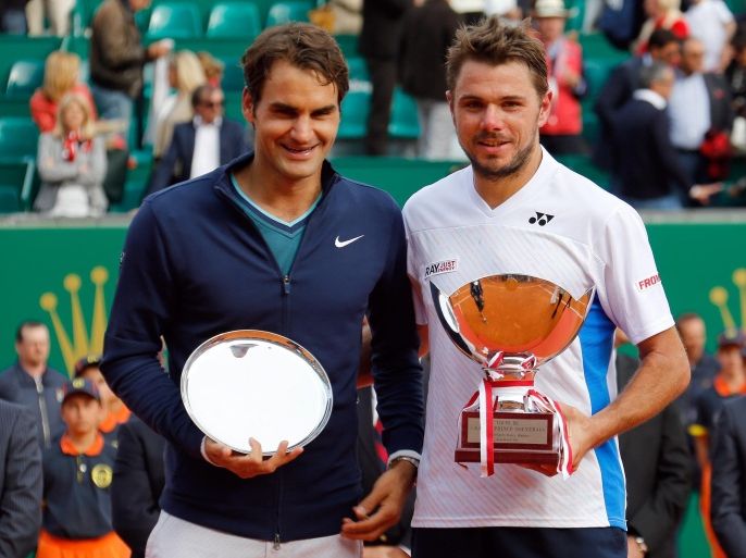 Stanislas Wawrinka of Switzerland, right, and Roger Federer of Switzerland hold their trophies after Wawrinka defeated Federer in the final match of the Monte Carlo Tennis Masters tournament, in Monaco, Sunday April 20, 2014. Wawrinka won 4-6, 7-6, 6-2. (AP Photo/Claude Paris)
