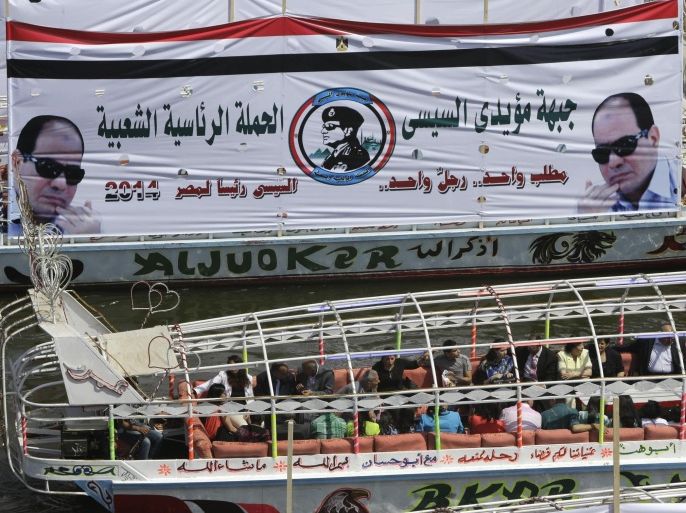 Egyptian holiday makers ride in a boat on the Nile River marking Sham el-Nessim, or “smelling the breeze,” in front of a giant banner supporting presidential hopeful Abdel-Fattah el-Sissi, the country's former military chief, in Cairo, Monday, April 21, 2014. Arabic reads,"the front of Sissi supporters, the popular presidential campaign." (AP Photo/Amr Nabil)