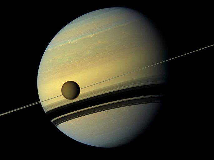 Titan, Saturn's largest moon appears before the planet as it undergoes seasonal changes in this natural color view from NASA's Cassini spacecraft in this handout released by NASA August 29, 2012. The moon measures 3,200 miles, or 5,150 kilometers, across and is larger than the planet Mercury. Cassini scientists have been watching the moon's south pole since a vortex appeared in its atmosphere in 2012.
