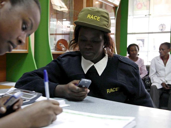 epa01166943 Security guard Susan Anyango is assisted to send money through an M-Pesa Agent based in a moble phone shop in Nairobi, 07 November, 2007. M-PESA is mobile service provider, Safaricom's, "mobile money", allowing users to transfer money using their mobile phone. Kenya is the first country in the world to use this service which helps users transfer small amounts of money to pay for goods and services or to send direct to relatives in villages without banks. EPA/BONIFACE MWANGI