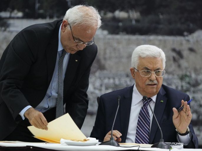 Palestinian president Mahmud Abbas (R) gestures as he signs a request to join 15 United Nations agencies at his headquarters in the West Bank city of Ramallah on April 1, 2014, in a move that could derail a US push to revive faltering peace talks with Israel. AFP PHOTO / ABBAS MOMANI