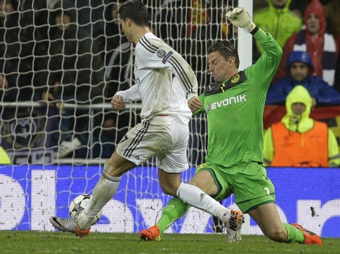 Real's Cristiano Ronaldo scores his side's first goal beating Dortmund goalkeeper Roman Weidenfeller during a Champions League quarterfinal first leg soccer match between Real Madrid and Borussia Dortmund at the Santiago Bernabeu stadium in Madrid, Spain, Wednesday April 2, 2014. (AP Photo/Paul White)