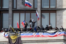 Pro-Russian activists who seized the main administration building in the eastern Ukrainian city of Donetsk hold Russian flag and the flag of so called Donetsk Republic on April 7, 2014. They proclaimed Monday the creation of a sovereign 'people's republic' independent of Kiev rule. The Interfax news agency reported that the self-proclaimed leaders of Donetsk vowed to hold a regional sovereignty referendum no later than May 11. AFP PHOTO/ ALEXANDER KHUDOTEPLY