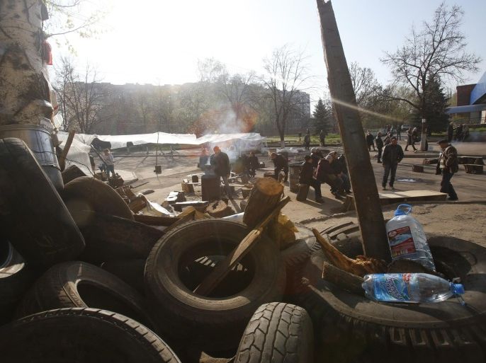 People gather in front of a barricade across a street in Slovyansk, eastern Ukraine, Wednesday, April 16, 2014. The city of Slovyansk has come under the increasing control of the pro-Russian gunmen who seized it last weekend. (AP Photo/Sergei Grits)
