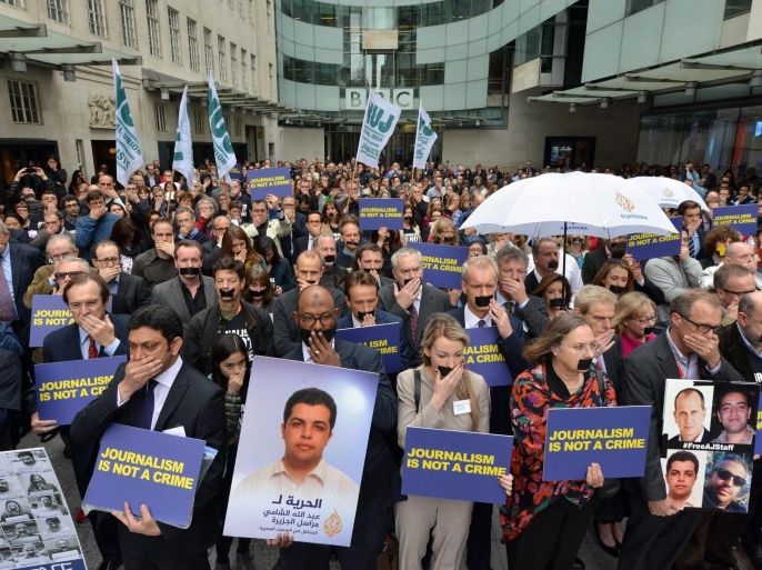 A handout photo dated 07 April 2014 and made available by BBC showing a protest in London, Britain, by BBC journalists in support of Aljazeera staff held under captivity in Egypt. BBC journalists gathered for a one minute silence with their mouths covered. EPA/JEFF OVERS / HANDOUT