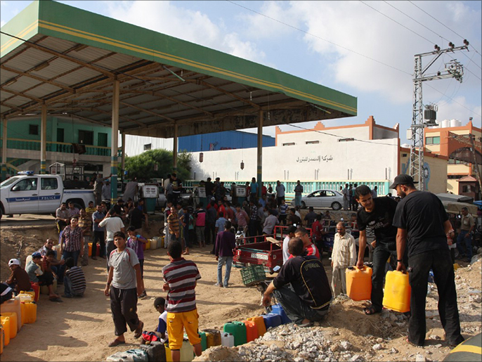 مواطنون وسط القطاع في انتظار قدوم الوقود لمحطات التوزيع (الجزيرة)