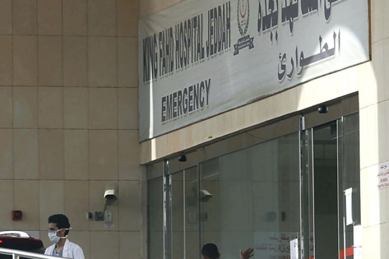 A Saudi medical staff and a security guard stand at the closed gate of the emergency department as exit and entry is banned at the city's King Fahd Hospital, on April 9, 2014 in Jeddah. The health ministry reported four more MERS cases in Jeddah, two of them among health workers, prompting authorities to close the emergency department at the city's King Fahd Hospital. AFP PHOTO/STR