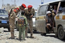 A student asks Yemeni soldiers to help access a street as authorities stepped up security measures a day after a drone attack killed 10 al-Qaeda suspected militants, in Sanaa, Yemen, 20 April 2014. An unspecified number of insurgents with suspected ties to al-Qaeda were killed 20 April 2014 in an airstrike in southern Yemen, a security official said, the second such attack in two consecutive days in the Arabian Peninsula country.
