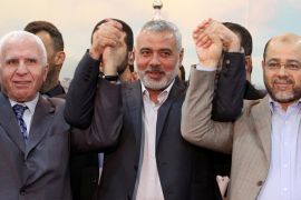 Senior Fatah official Azzam Al Ahmad (L), Hamas Prime minister Sheikh Ismael Haneiya (C) and senior Hamas leader Moussa Abu Marzouk (R) join hands after the announcement of an agreement between the two rival Palestinian groups, in Gaza City, 23 April 2014. Others are not identified. Palestinian rival movements Hamas and Fatah on 23 April agreed to form a unity government and hold general elections. The two rivals have been embroiled in a rift since 2006, after Hamas unexpectedly beat the secular Fatah in parliamentary elections, conducted exactly a year after Mahmoud Abbas won a presidential poll.