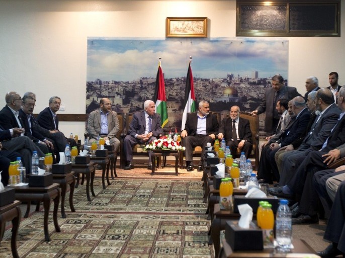 Hamas deputy leader Musa Abu Marzuk (back-L) speaks with the head of the delegation of the Palestine Liberation Organisation (PLO) and senior figure in the mainstream Fatah party of president Mahmud Abbas, Azzam al-Ahmad (back-2L), while Hamas prime minister in the Gaza Strip Ismail Haniya (back-2R), and deputy head of the Palestinian Parliament Ahmad Bahar (back-R) attend a meeting with members of the PLO delegation and leaders of Palestinian factions in Gaza City on April 22, 2014. The Palestinians have relaunched efforts to reconcile their rival leaderships in the West Bank and Gaza Strip as US-brokered peace talks with Israel teeter on the edge of collapse. AFP PHOTO /MAHMUD HAMS