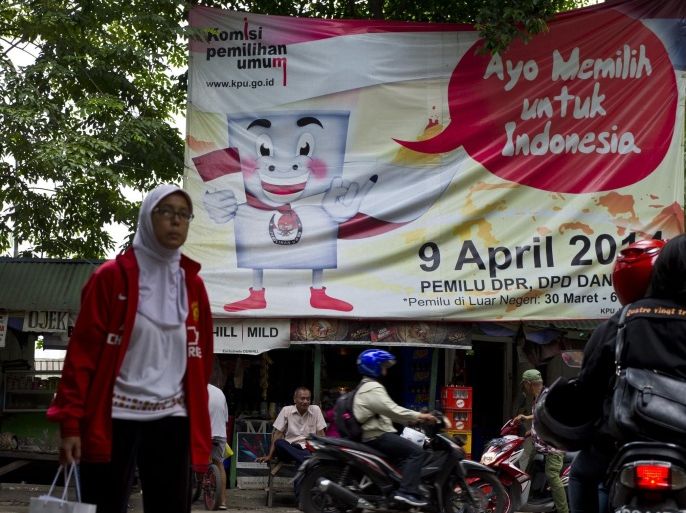A large poster from Indonesia's General Elections Commission urging residents to vote in the April 9 legislative elections is displayed along a street in Jakarta on April 4, 2014. Some 186 million votesr are eligible to cast ballots in the legislative elections in the world's third biggest democracy and set the stage for presidential elections in July as President Susilo Bambang Yudhoyono's second term ends. AFP PHOTO / ROMEO GACAD