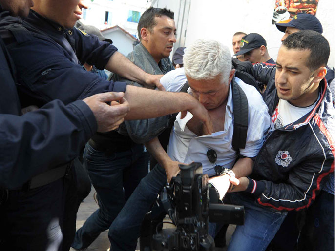 مشادات بين الصحفيين والأمن خارج مركز الانتخابات الذي صوت فيه بوتفليقة (الفرنسية)