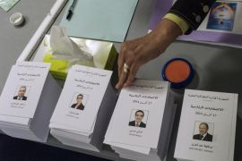 An Algerian woman takes a ballot before voting at a polling station in the Algerian Embassy on April 12, 2014 in Paris. Algeria's Abdelaziz Bouteflika, who is running for a fourth term in Thursday's presidential vote, is widely expected to win despite his frail health preventing him from even campaigning. The 77-year-old has appeared only rarely in recent months, and his decision to seek a new mandate has provoked derision and drawn sharp criticism from senior political figures questioning his ability to rule after he suffered a mini-stroke last year. AFP PHOTO / FRED DUFOUR