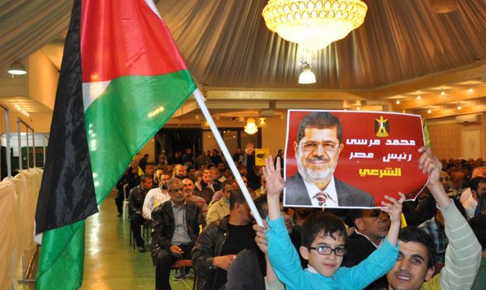 طفل بالمهرجان يلوح بالعلم الفلسطيني ويرفع صورة الرئيس المعزول محمد مرسي