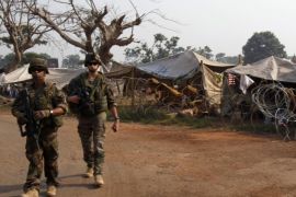 French soldiers from the peacekeeping forces walk near a camp for displaced people at M'Poko international airport in Bangui February 20, 2014 file photo. REUTERS/Luc Gnago