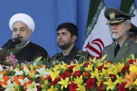 Iranian President Hassan Rouhani, second left, speaks in a military parade marking National Army Day as Chief of the General Staff of Iran's Armed Forces, Gen. Hasan Firouzabadi, left, and army commander Gen. Ataollah Salehi, right, listen, in front of the mausoleum of the late revolutionary founder Ayatollah Khomeini, just outside Tehran, Iran, Friday, April 18, 2014. Ahead of the parade, Rouhani underscored his moderate policies and outreach to the West in a speech. (AP Photo/Vahid Salemi)