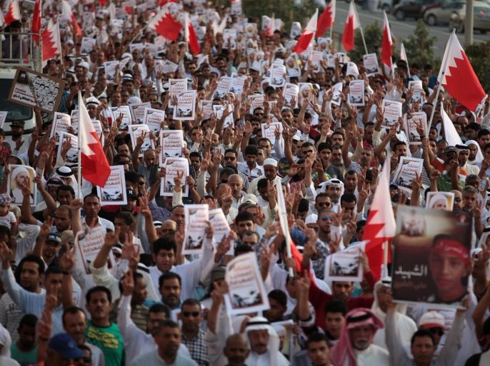 Thousands of Bahraini anti-government protesters, waving national flags, signs and pictures of jailed political figures and people killed in unrest, chant slogans during a march organized by opposition groups in A'ali, Bahrain, Friday, April 18, 2014. Signs read "the kingdom of demolished mosques," referring to Shiite mosques that were demolished by authorities during the crackdown that followed the 2011 pro-democracy uprising. (AP Photo/Hasan Jamali)