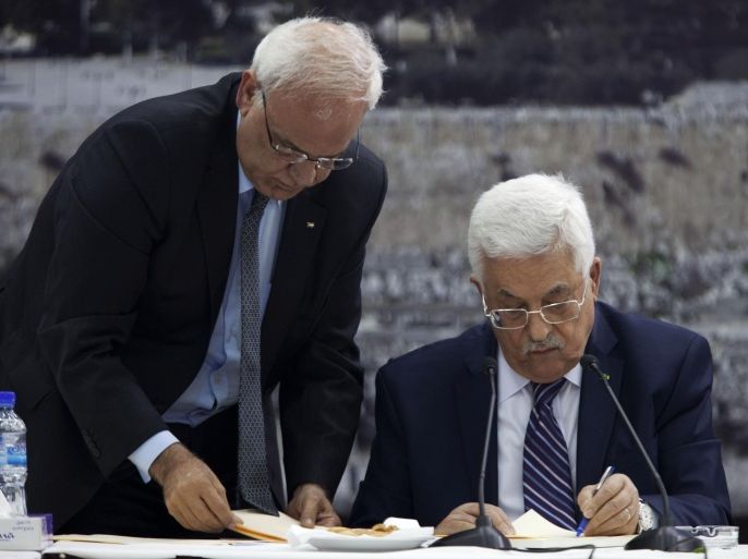 Palestinian President Mahmoud Abbas, right, jointed by Palestinian chief peace negotiator Saeb Erekat, signs an application to the U.N. agencies in the West Bank city of Ramallah, Tuesday, April 1, 2014. In a dramatic move that could derail eight months of U.S. peace efforts, President Abbas resumed a Palestinian bid for further U.N. recognition despite a promise to suspend such efforts during nine months of negotiations with Israel. Abbas signed "State of Palestine" applications for 15 U.N. agencies in a hastily convened ceremony after Israel calls off a promised prisoner release. (AP Photo/Majdi Mohammed)