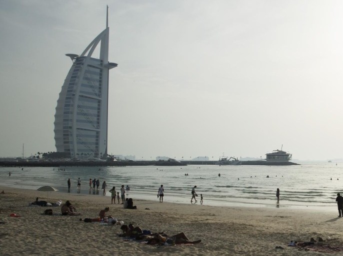 DUBAI, UNITED ARAB EMIRATES - APRIL 17: People enjoy Umm Suqeim Beach near the luxury Burj Al Arab Hotel on April 17, 2014 in Dubai, United Arab Emirates.