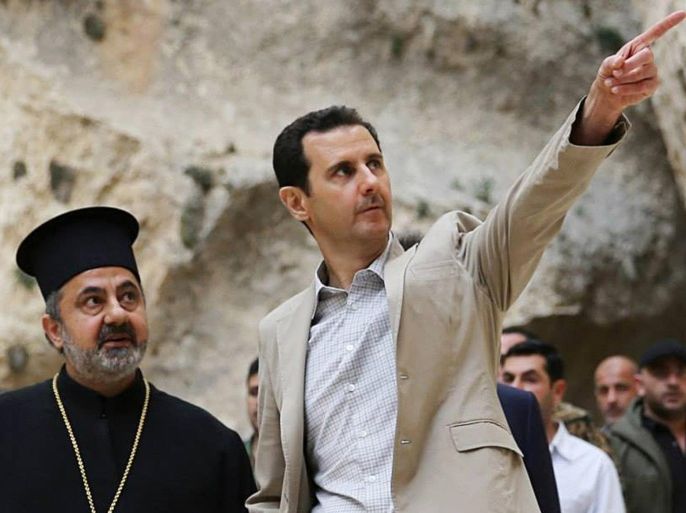 In this photo taken on Sunday April 20, 2014 and released by the Syrian official news agency SANA, Syrian President Bashar Assad, right, visits the Christian village of Maaloula, near Damascus, Syria. Assad visited on Sunday a historic Christian village his forces recently captured from rebels, state media said, as the country's Greek Orthodox Patriarch vowed that Christians in the war-ravaged country "will not submit and yield" to extremists. The rebels, including fighters from the al-Qaida-affiliated Nusra Front, took Maaloula several times late last year. (AP Photo/SANA)