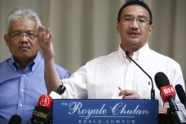 Malaysian Deputy Minister of Foreign Affairs Hamzah Zainudin, left, listens as Malaysia's acting Transport Minister Hishammuddin Hussein answers a question from a journalist during a press conference on the missing Malaysia Airlines Flight 370 at a hotel in Kuala Lumpur, Malaysia, Saturday, April 19, 2014. An underwater robotic submarine is expected to finish searching a narrowed down area of the Indian Ocean seabed for the missing Malaysia Airlines plane within the next week, after completing six missions and so far coming up empty, the search coordination center said Saturday. (AP Photo/Vincent Thian)