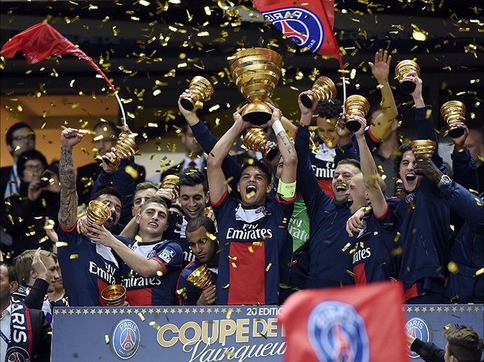 Paris' Brazilian defender Thiago Silva holds the trophy as he celebrates with team mates winning the French League Cup final football match between Paris Saint-Germain (PSG) and Lyon (OL) on April 19, 2014 at the Stade