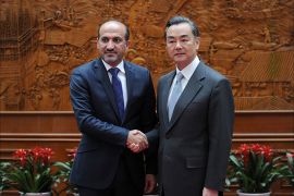 The head of Syria's opposition National Coalition, Ahmad Jarba (L), shakes hands with Chinese Foreign Minister Wang Yi (R) before their meeting at the Chinese Foreign Ministry in Beijing on April 16, 2014.